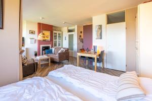 a bedroom with a bed and a living room at Appartementencomplex Juliana 158 in De Koog +4 photos