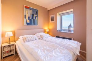 a bedroom with a large white bed and a window at Appartementencomplex Juliana 158 in De Koog