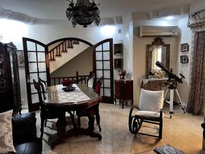 a living room with a table and chairs and a staircase at Dar Cirta in Sicca Veneria