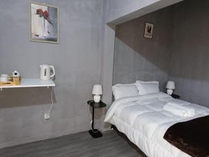 a bedroom with a large white bed and two lamps at The Huts in Vila Praia Do Bilene