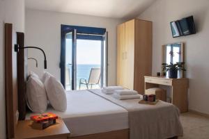 a bedroom with a bed with a view of the ocean at OdeSea Aegean Studios in Plomari
