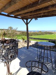 a patio with two chairs and a table and a grill at Suêrte cyprus in Akanthou