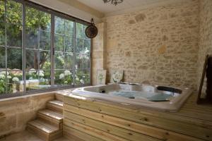 a bath tub in a room with a large window at Le Clos Réaud in Blaye