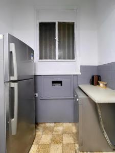 a kitchen with a window and a stainless steel refrigerator at Nile & Museum Hideaway Haraka in Cairo