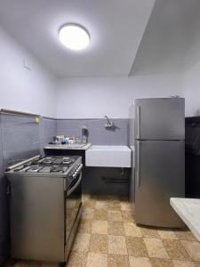 a kitchen with a stove and a sink and a refrigerator at Nile & Museum Hideaway Haraka in Cairo +13 photos