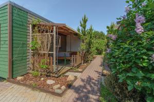 a garden with a green building next to a house at Pylimo slėnis in Palanga