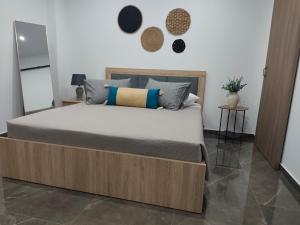 a bedroom with a bed with a wooden frame at Argiros Apartments in Kefalos