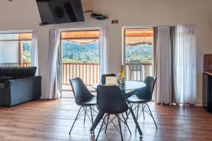a living room with a table and chairs and windows at עיינות ספיר - Einot Sapir in Sappir