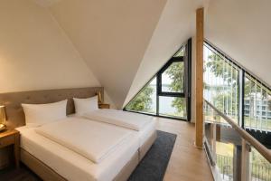a bedroom with a bed and a large window at Maremüritz Yachthafen Resort in Waren +113 photos