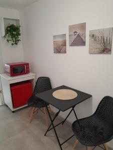 a table and chairs in a room with a microwave at Garsoniera Serena in Saturn