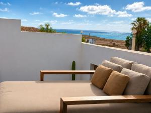 a couch sitting on a balcony with a view of the ocean at Casa Abora - Ocean Views, Private Pool & Sunsets in La Pared