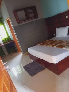 a bedroom with a bed in a room at Amsterdam Hôtel in Douala