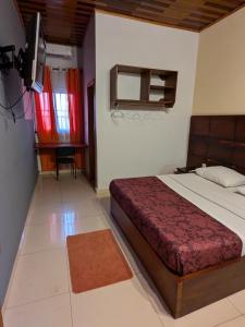 a bedroom with a bed and a television in it at Amsterdam Hôtel in Douala