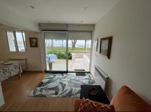 a living room with a large sliding glass door at Comillas 30 Primera Línea de Playa in Comillas