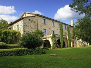 a large brick building with a staircase in a yard at Holiday Home in Ardèche near Château de Ventadour in Fabras