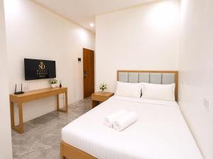 a bedroom with a white bed and a desk at SD HOTEL Taytay in Taytay