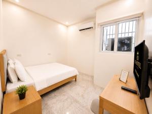 a small white bedroom with a bed and a window at SD HOTEL Taytay in Taytay