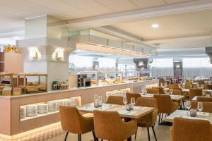 a restaurant with tables and chairs and a counter at ALEGRIA Florida & Spa in Santa Susanna