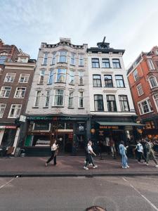 a group of people crossing a street in front of a building at Hotel Damsquare in Amsterdam