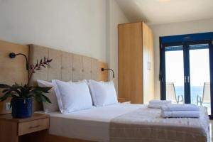 a bedroom with a large bed with white pillows at OdeSea Aegean Studios in Plomari +26 photos