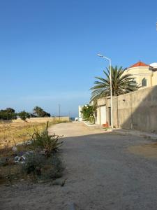 an empty street with a building and a palm tree at dreams beach city in Sousse