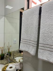 a bathroom with a towel hanging on a sink at Casa Temporada Espaço Vip in Barra do Garças +36 photos
