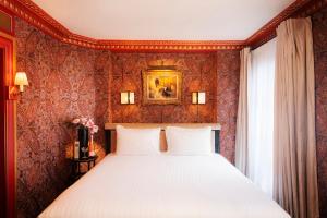 a bedroom with a bed with red wallpaper at Maison Proust, Hotel & Spa La Mer in Paris