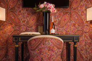 a desk with a vase of flowers and a chair at Maison Proust, Hotel & Spa La Mer in Paris +84 photos