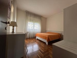 a bedroom with an orange bed and a window at Casa Vacanze Revè in Possagno