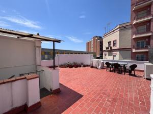 a patio with tables and chairs on top of a building at Private Terrace House near Camp Nou in Hospitalet de Llobregat