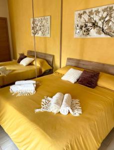two beds with towels and pillows on top of them at Fiorucci Apartments - Veronica's House in Rome