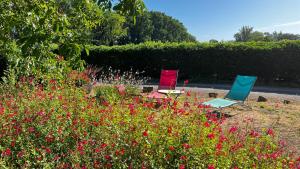 two chairs and a table in a garden with flowers at Virevent in Carcassonne