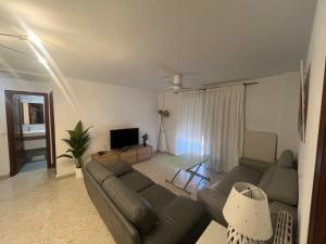 a living room with a couch and a television at Brisa de la Laguna in Chipiona +11 photos