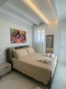 a bedroom with a large bed with towels on it at Domoo Boutique Hotel in Torraca +14 photos