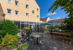 a building with a picnic table and benches in front of it at B&B HOTEL Chartres Centre Cathédrale 3 étoiles in Chartres
