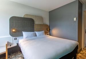 a bedroom with a large white bed in a room at B&B HOTEL Chartres Centre Cathédrale 3 étoiles in Chartres +51 photos