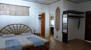 a bedroom with a bed and a room with a table at Marcosas Cottages Resort in Basdiot +57 photos