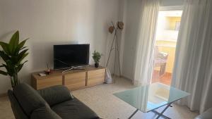 a living room with a couch and a tv on a table at Brisa de la Laguna in Chipiona