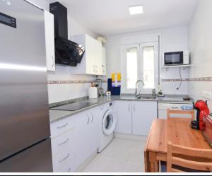 a kitchen with white cabinets and a stainless steel refrigerator at Brisa de la Laguna in Chipiona