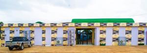 ein Gebäude, vor dem ein Lastwagen parkt in der Unterkunft Hôtel LEWI 2 Bouaké in Bouaké