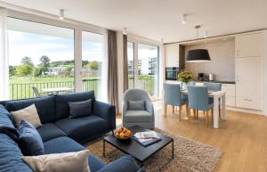 a living room with a blue couch and a kitchen at Maremüritz Yachthafen Resort in Waren