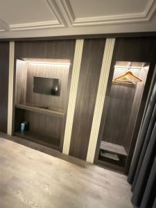 a room with a wall with a tv and a shelf at Residence Hotel By Ketenci in İzmir