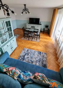 a living room with a blue couch and a table at Sen nad Bałtykiem - Apartament z balkonem, Ustka in Ustka