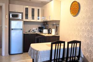 a kitchen with a white refrigerator and a table and chairs at Harmony Suites apartment 4 floor in Sunny Beach