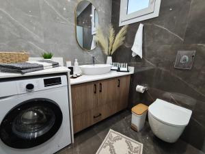 a bathroom with a washing machine and a sink at Argiros Apartments in Kefalos