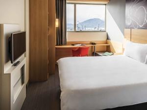 a hotel room with a bed and a television at ibis Santos Valongo in Santos
