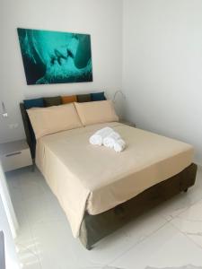 a bedroom with a bed with two towels on it at Domoo Boutique Hotel in Torraca