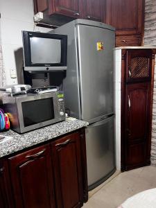 a kitchen with a refrigerator and a microwave and a tv at Dar Cirta in Sicca Veneria