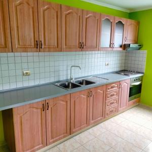 a kitchen with wooden cabinets and a sink at Adventure Beach Hostal in Durrës