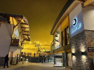 a group of buildings with people walking on a street at night at Central Golden Apartment in Nowy Sącz